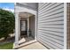 Inviting front porch with decorative columns, wood accents, a glass-paneled door, and lush greenery enhancing curb appeal at 5830 Sterling Ct, Cumming, GA 30040