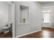 Neutral hallway boasts hardwood floors, custom art niche, and a door leading to a half bathroom at 5830 Sterling Ct, Cumming, GA 30040