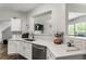 Kitchen with stainless appliances, quartz countertops, and views of the living room at 5830 Sterling Ct, Cumming, GA 30040