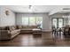 Spacious living room with hardwood floors, neutral sectional, and abundant natural light from large windows at 5830 Sterling Ct, Cumming, GA 30040