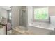 Bright primary bathroom with a soaking tub and separate glass-enclosed shower at 5830 Sterling Ct, Cumming, GA 30040