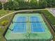 Aerial view of two tennis courts surrounded by lush landscaping and fencing at 5830 Sterling Ct, Cumming, GA 30040