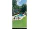 Sparkling swimming pool with slide, fun floats, and a lounge area surrounded by greenery at 10 Callaway Ct, Hiram, GA 30141