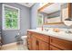 Well-lit bathroom featuring a wood vanity, large mirror, and a shower at 10 Callaway Ct, Hiram, GA 30141