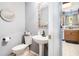 Powder room with pedestal sink, decorated mirror, adjacent to the kitchen at 10 Callaway Ct, Hiram, GA 30141