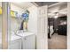 Bright laundry area with washer, dryer, and shelf space, with a view to a bedroom at 10 Callaway Ct, Hiram, GA 30141