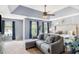 Main bedroom with tray ceiling, sitting area, and large windows overlooking exterior greenery at 10 Callaway Ct, Hiram, GA 30141