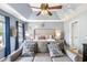 Main bedroom with tray ceiling, sitting area, and large windows overlooking exterior greenery at 10 Callaway Ct, Hiram, GA 30141