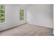 Bright bedroom featuring two windows for lots of light, and neutral colored carpet at 1024 Odelle Cir, Mcdonough, GA 30253