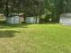 Large green backyard featuring several storage sheds and tree coverage at 105 Lena Cir, Stockbridge, GA 30281