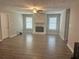 Living room with fireplace, ceiling fan, wood-look floors, and windows at 105 Lena Cir, Stockbridge, GA 30281