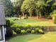 Manicured backyard with lush landscaping, mature trees, and an inviting in-ground pool at 284 Harris Loop, Dallas, GA 30157