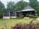 Charming home featuring dark siding, brick foundation, covered porch, and inviting landscaping at 284 Harris Loop, Dallas, GA 30157