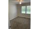 Serene bedroom with neutral paint, plush carpet, and natural light streaming through bright windows at 66 Lakeshore Dr, Bowdon, GA 30108