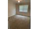 Comfortable bedroom showcasing neutral walls, plush carpeting, and natural light through two windows at 66 Lakeshore Dr, Bowdon, GA 30108