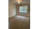Bright bedroom featuring carpet, a ceiling fan, and a large window at 66 Lakeshore Dr, Bowdon, GA 30108