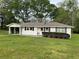 Inviting single-story home with a well-maintained lawn, white siding, and a convenient covered carport at 66 Lakeshore Dr, Bowdon, GA 30108