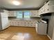 Bright kitchen with white cabinets, laminate flooring, and essential appliances for convenient meal preparation at 66 Lakeshore Dr, Bowdon, GA 30108