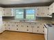 Well-lit kitchen equipped with classic white cabinets, laminate floor, and plentiful counter space at 66 Lakeshore Dr, Bowdon, GA 30108