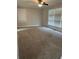Cozy living room featuring soft carpet, neutral decor, and lots of natural light from the window at 66 Lakeshore Dr, Bowdon, GA 30108