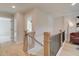 Upstairs hallway with wood floors and a decorative black metal and wood staircase at 133 Prescott Manor Dr, Canton, GA 30115