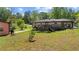 Backyard view featuring a brick home with a deck, carport, and ample outdoor space surrounded by mature trees at 2365 Fontaine Cir, Decatur, GA 30032