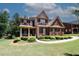 Charming two-story brick home with a welcoming front porch and manicured landscaping at 2405 Brisbane Dr, Conyers, GA 30013