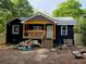 Shows the exterior of this black house with a yellow porch being rebuilt at 388 Sargent Se Dr, Atlanta, GA 30315