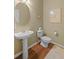 Charming half bathroom with pedestal sink, classic fixtures, and hardwood floors at 441 Mountain View Ln, Woodstock, GA 30188