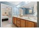 Bathroom featuring dual sinks, wood cabinets, and access to a bedroom and tub at 441 Mountain View Ln, Woodstock, GA 30188