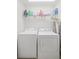 Laundry room with stacked washer and dryer and shelf for storing laundry detergent at 441 Mountain View Ln, Woodstock, GA 30188