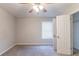 Bright bedroom with ceiling fan, window, soft carpet, and a walk-in closet for ample storage at 1045 Summer Hill Nw Ct, Acworth, GA 30102