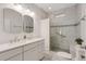 Bathroom featuring double sinks, tiled floor, glass shower and a tiled accent wall at 120 Warren Ne St, Atlanta, GA 30317