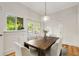 Elegant dining room featuring a large wood table, white chairs, and a view to the outdoors at 120 Warren Ne St, Atlanta, GA 30317