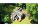 Aerial view of a home with a wooden deck surrounded by lush green trees and a well-manicured lawn at 2926 Swarthmore Dr, Lawrenceville, GA 30044