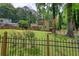 View of the home's backyard, showcasing a well-maintained lawn, mature trees, and a lovely iron fence at 2926 Swarthmore Dr, Lawrenceville, GA 30044