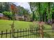 Spacious backyard featuring lush green lawn, privacy fence, and a charming two-story house at 2926 Swarthmore Dr, Lawrenceville, GA 30044