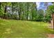 A lush green lawn slopes up to a border of mature trees in this spacious backyard at 2926 Swarthmore Dr, Lawrenceville, GA 30044