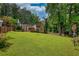 Backyard featuring a well-maintained lawn, mature trees, and fenced perimeter at 2926 Swarthmore Dr, Lawrenceville, GA 30044