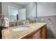 Bathroom with double sink vanity with granite countertop, wooden cabinets, and chrome fixtures at 2926 Swarthmore Dr, Lawrenceville, GA 30044