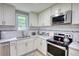 Bright kitchen features stainless steel appliances, white cabinets and tiled backsplash at 2926 Swarthmore Dr, Lawrenceville, GA 30044