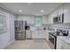 Bright kitchen features stainless steel appliances, white cabinets and tiled backsplash at 2926 Swarthmore Dr, Lawrenceville, GA 30044