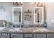 Bathroom featuring double vanities, granite countertops, and stylish, lighted mirrors at 3637 Sweet Ashley Ln, Loganville, GA 30052