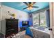Comfortable bedroom with a fan and natural light, featuring a unique blue ceiling and playful decor at 3637 Sweet Ashley Ln, Loganville, GA 30052