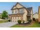 Charming two-story home with tan siding, stone accents, and a well-manicured front yard at 3637 Sweet Ashley Ln, Loganville, GA 30052