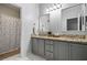 Bright bathroom featuring a double vanity with granite countertop and gray cabinets at 508 Vinings Forest Se Ct, Smyrna, GA 30080