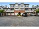 Exterior of a townhome with gray siding, brick accents, attached garages, and parking spaces at 508 Vinings Forest Se Ct, Smyrna, GA 30080