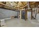 Spacious unfinished basement with a storage room and exposed beams and ductwork at 6420 Marbut Rd, Lithonia, GA 30058