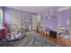 Spacious bedroom features light purple walls, plush carpet and colorful decor at 6420 Marbut Rd, Lithonia, GA 30058