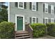 Up close view of home featuring a green front door, a small porch, and manicured hedges at 6420 Marbut Rd, Lithonia, GA 30058